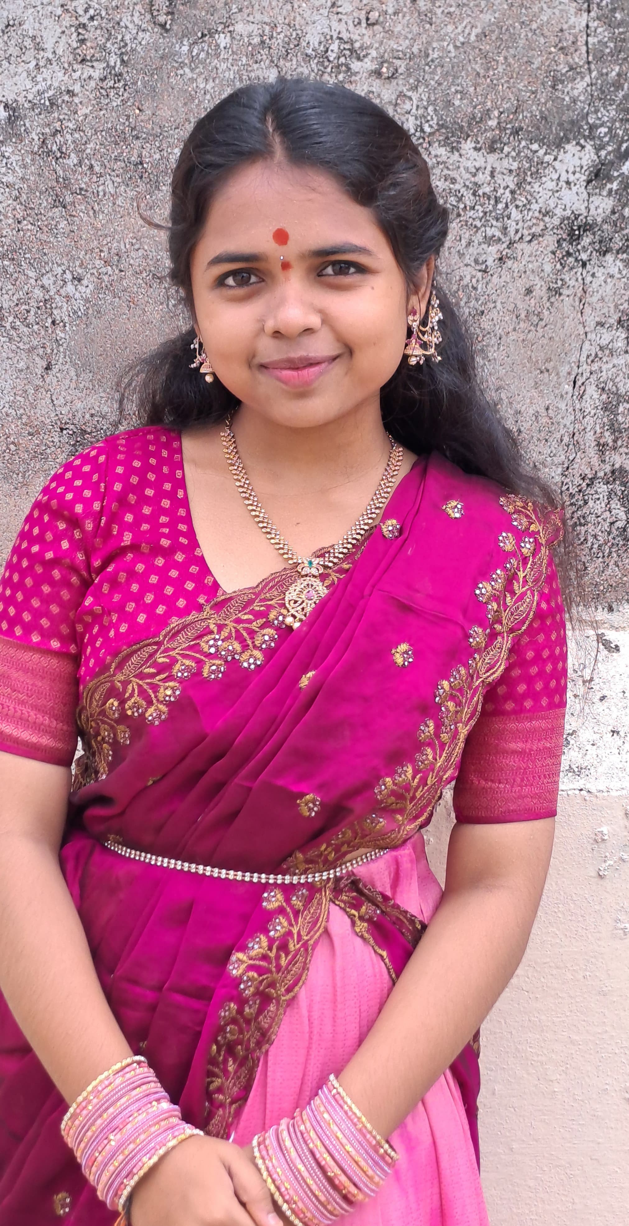Ammulu smiling in a pink saree